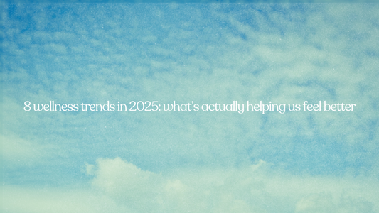 Soft, cloudy blue sky background with white serif text that reads “8 wellness trends in 2025: what’s actually helping us feel better.”